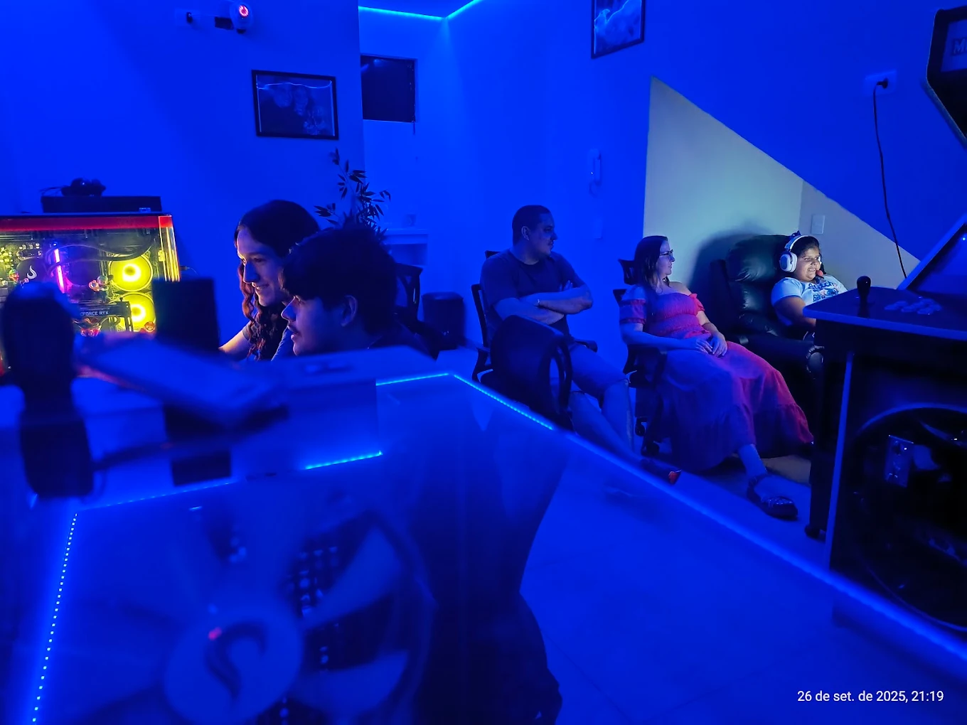 Clientes no ambiente com iluminação azul da Espaço Gamer